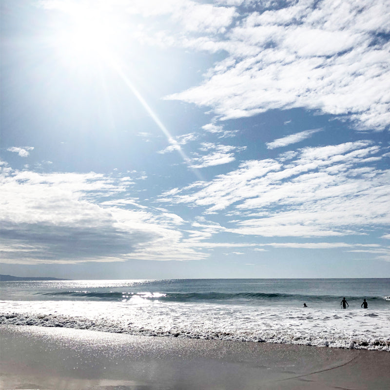 Sun flare over beach with clouds